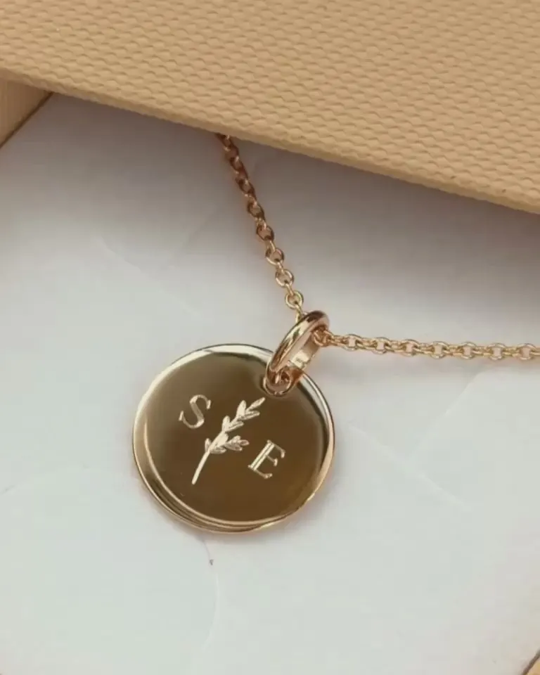 Médaille en plaqué or gravée des initiales S et E et d'un brin de lavande